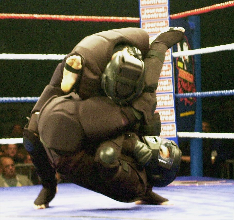 Two participants in full HIGH GEAR® grappling during a live demonstration